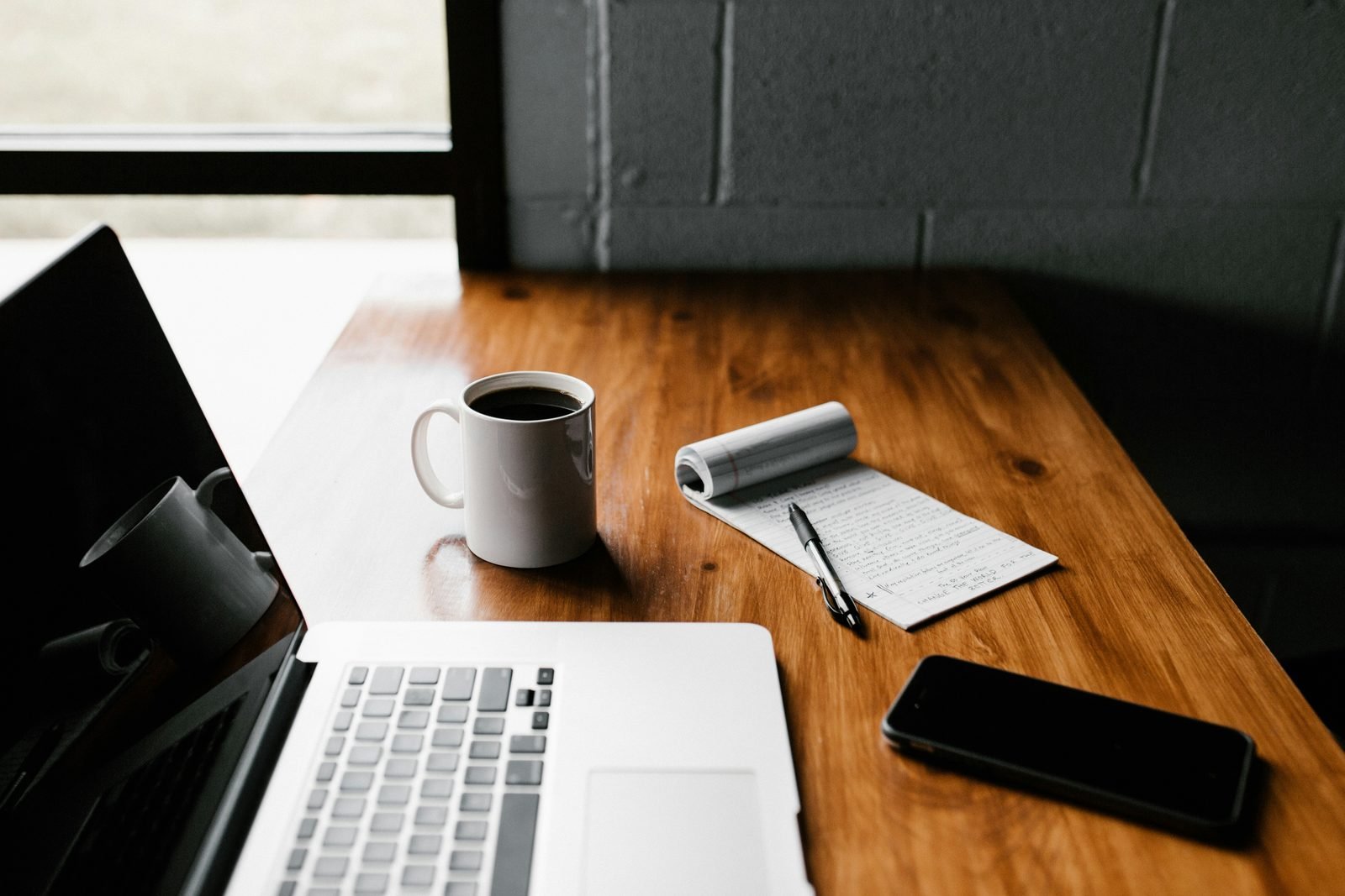 Laptop, coffee and notepad on a work desk
